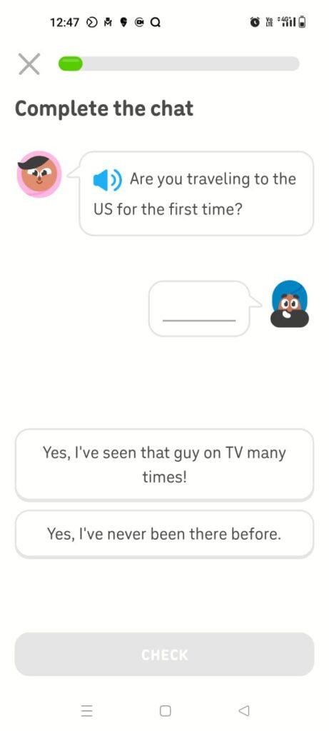 An interactive dialogue exercise screen inside the Duolingo language learning mobile application. The layout prompts the user to select the correct contextual text response to an audio-tracked conversation bubble asking 'Are you traveling to the US for the first time?